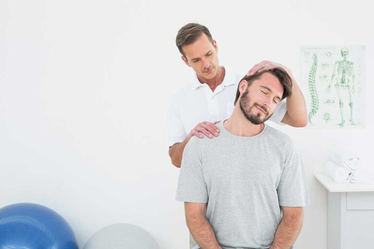 Person receiving gentle spinal care while practicing calm breathing in a quiet treatment room.