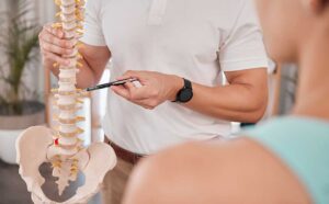 A senior woman receives a gentle chiropractic adjustment while seated in a comfortable clinic.