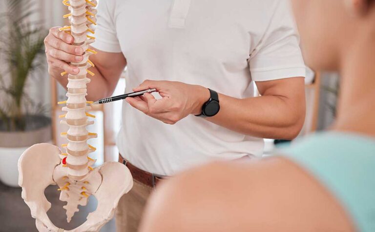 A senior woman receives a gentle chiropractic adjustment while seated in a comfortable clinic.